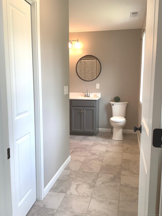 3 Henry Rd, Enfield, CT 06082 - bathroom featuring marble look tile flooring, vanity, baseboards, and toilet