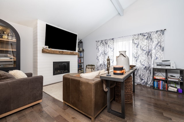 living room with vaulted ceiling with beams, a large fireplace, and dark wood finished floors