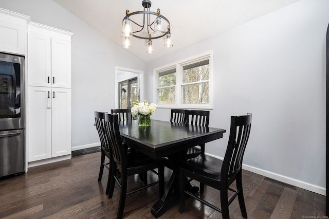 dining room featuring a chandelier, visible vents, baseboards, lofted ceiling, and dark wood-style floors