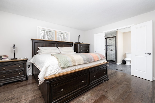bedroom with ensuite bathroom, baseboards, and dark wood-style flooring