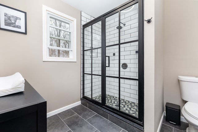 full bathroom with a shower stall, toilet, baseboards, and tile patterned floors