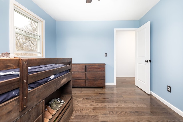 bedroom with ceiling fan, baseboards, and dark wood-style flooring
