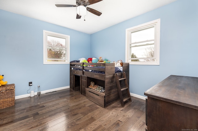bedroom featuring ceiling fan, baseboards, wood finished floors, and multiple windows