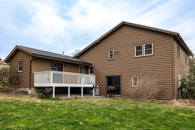 back of property with a wooden deck and a yard