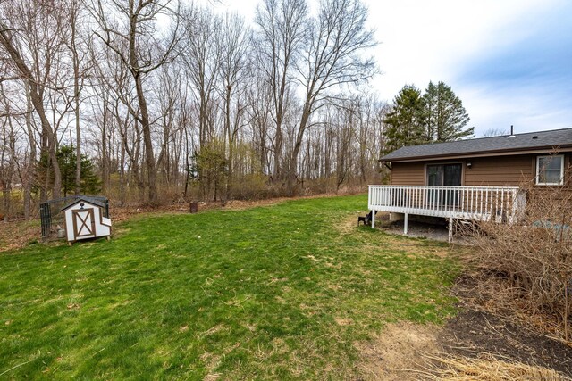 view of yard with a wooden deck, an outbuilding, and a shed