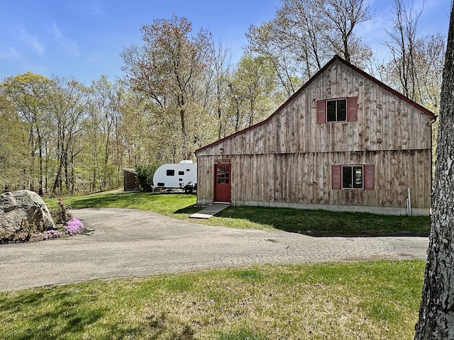 exterior space featuring a barn, an outbuilding, a yard, and driveway