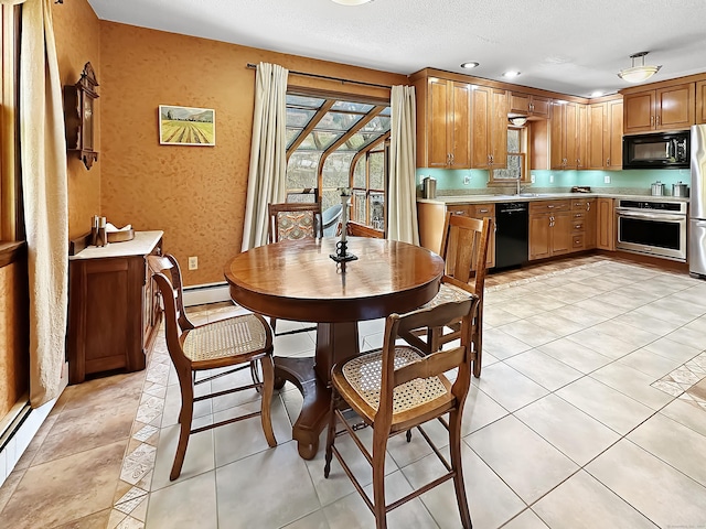 dining room featuring a textured ceiling and a baseboard heating unit