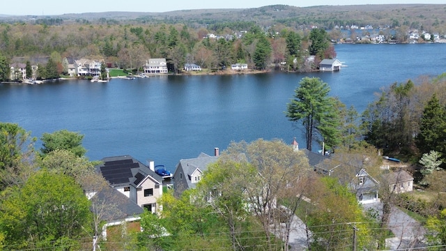 drone / aerial view with a water view, a residential view, and a wooded view
