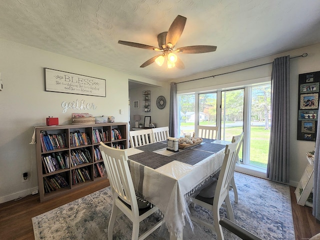 dining space featuring baseboards, ceiling fan, and wood finished floors