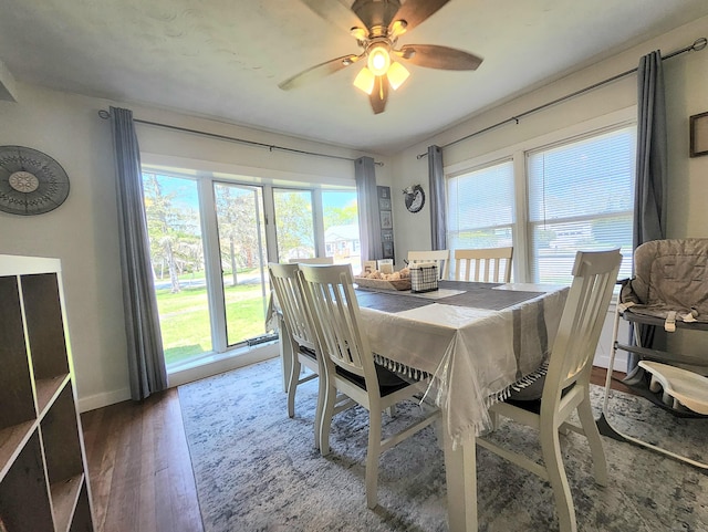 dining room with baseboards, ceiling fan, and wood finished floors