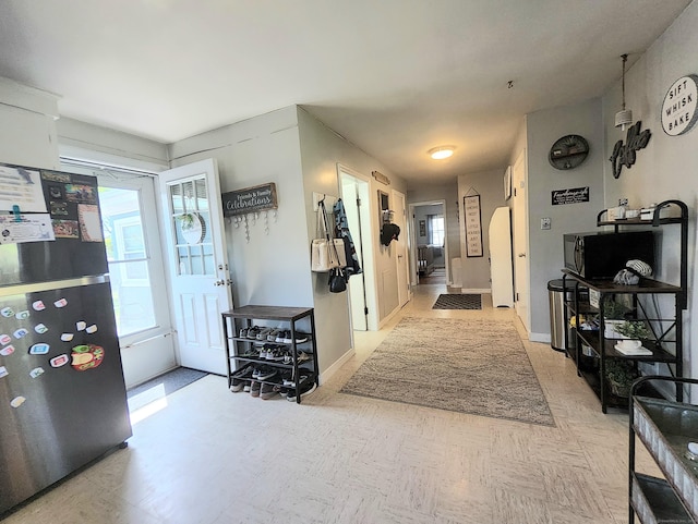 entryway featuring baseboards and light floors