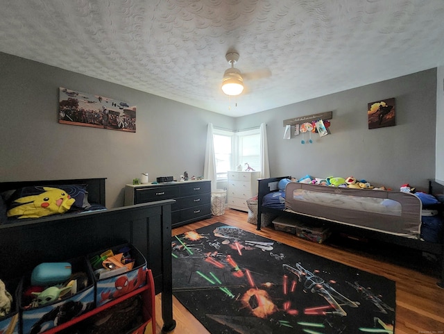 bedroom featuring a textured ceiling, ceiling fan, and wood finished floors