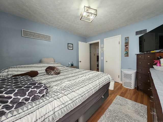 bedroom featuring visible vents and wood finished floors