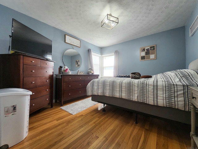 bedroom featuring light wood-style floors and a textured ceiling