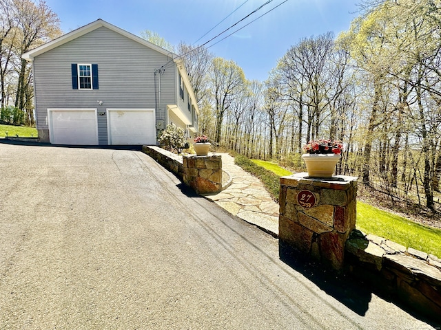 view of home's exterior with a garage and aphalt driveway
