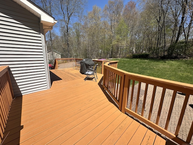 wooden deck with a yard and grilling area