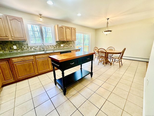 kitchen featuring decorative backsplash, pendant lighting, baseboard heating, a sink, and light tile patterned flooring