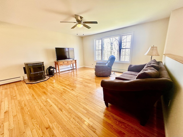 living area featuring baseboard heating, a ceiling fan, and light wood finished floors