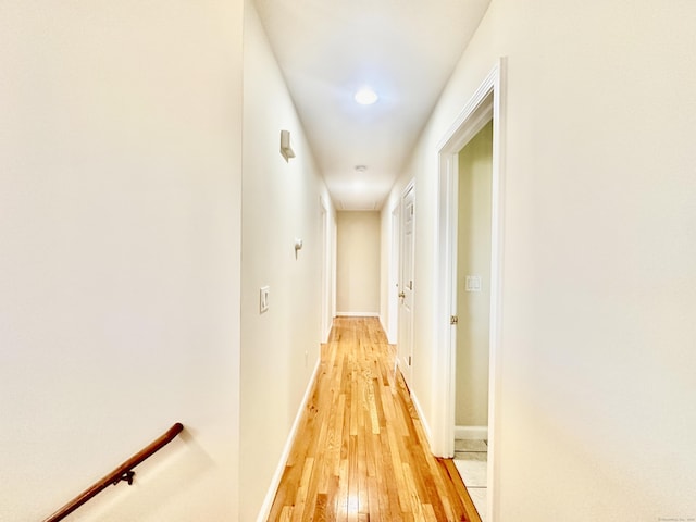corridor with baseboards, recessed lighting, and light wood finished floors