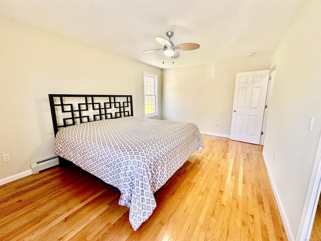 bedroom featuring baseboards, ceiling fan, a baseboard heating unit, and hardwood / wood-style flooring