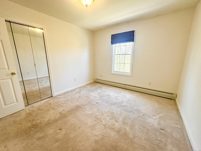 unfurnished bedroom featuring carpet floors, a baseboard radiator, baseboards, and a closet