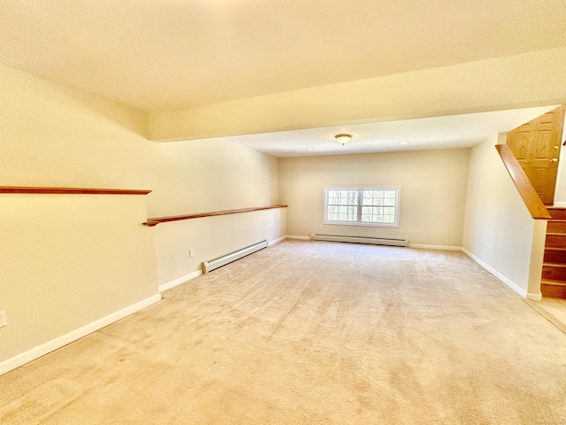 carpeted spare room featuring stairway, baseboards, and baseboard heating