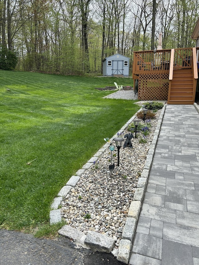 view of yard with an outdoor structure, stairs, and a deck