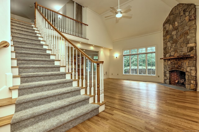 395 Isinglass Rd, Shelton, CT 06484 - stairway featuring ceiling fan, wood finished floors, high vaulted ceiling, a stone fireplace, and baseboards