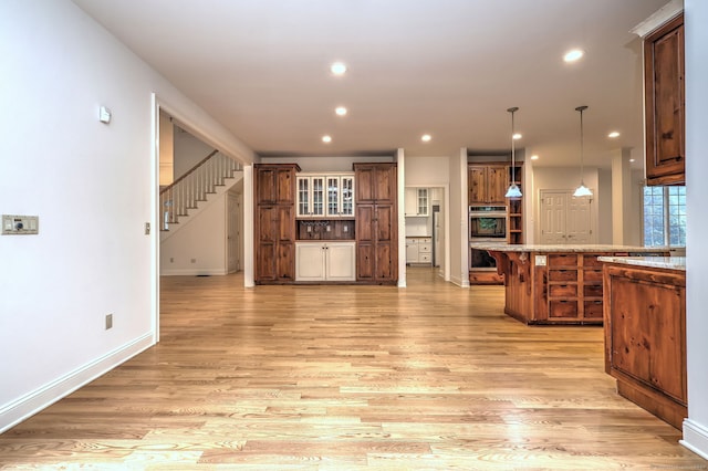 395 Isinglass Rd, Shelton, CT 06484 - kitchen featuring double oven, light wood-style flooring, recessed lighting, brown cabinets, and a breakfast bar area