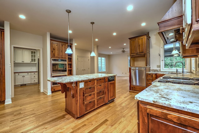 395 Isinglass Rd, Shelton, CT 06484 - kitchen with a kitchen island, light wood-style flooring, a sink, stainless steel appliances, and brown cabinets