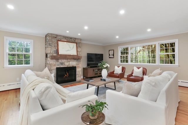 living room featuring a baseboard radiator, light wood-style floors, recessed lighting, ornamental molding, and a fireplace