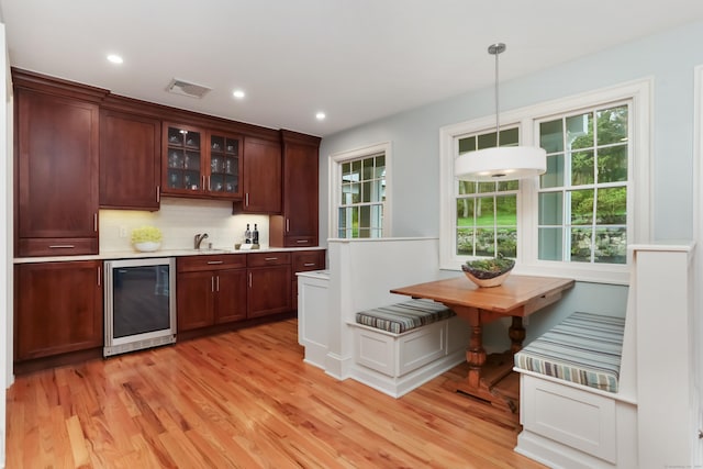 bar with recessed lighting, indoor wet bar, light wood-type flooring, visible vents, and beverage cooler