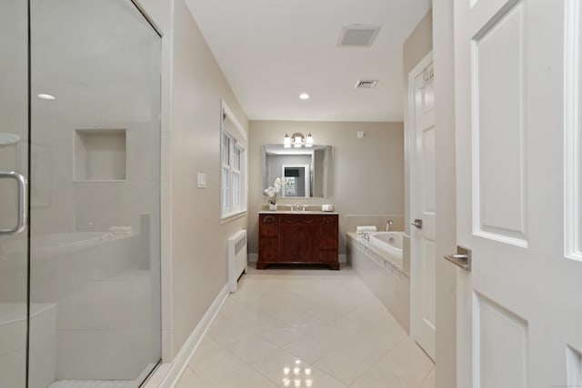 bathroom featuring tile patterned floors, radiator heating unit, a stall shower, and a garden tub