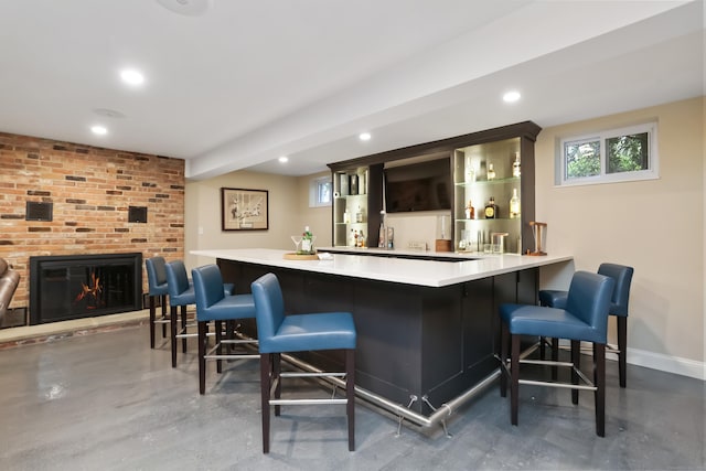 bar with a fireplace, a healthy amount of sunlight, wet bar, and baseboards