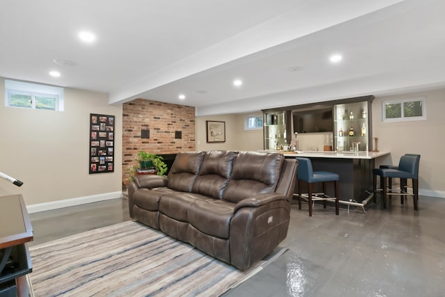 living room with finished concrete flooring, recessed lighting, and baseboards