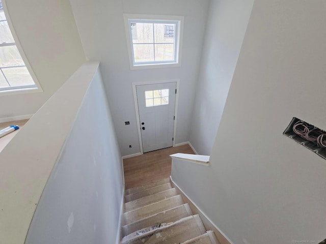 staircase featuring wood finished floors and baseboards