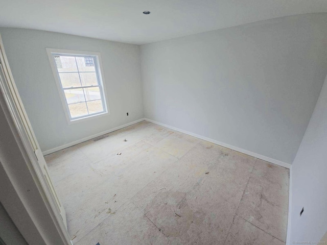 spare room with baseboards