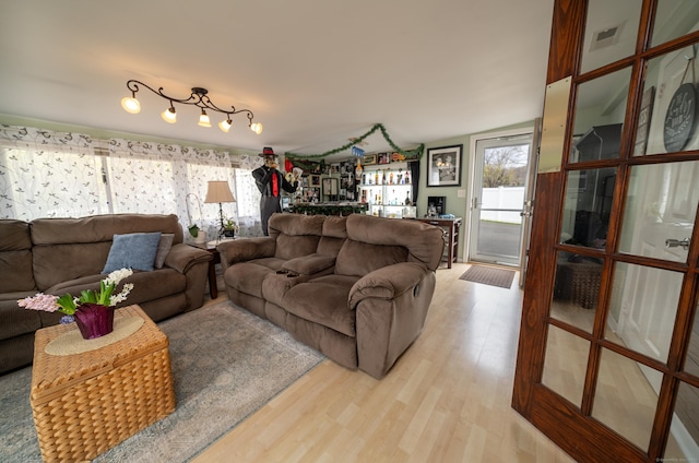 living area with a bar and light wood-type flooring