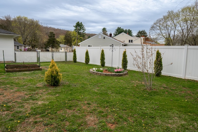 view of yard with a garden and a fenced backyard