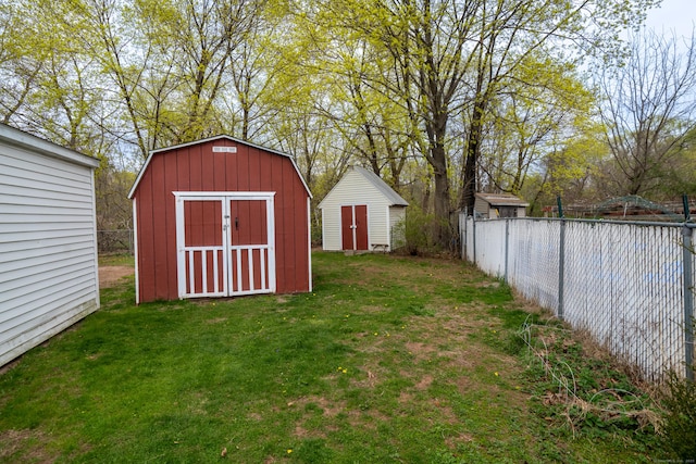 view of yard with fence, a storage unit, and an outdoor structure