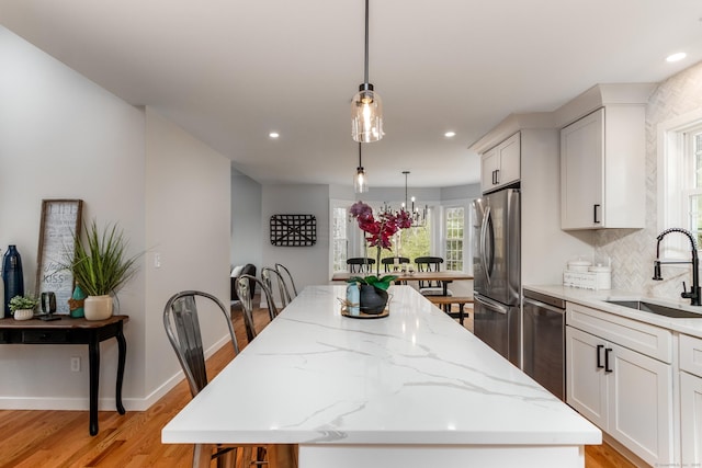 19 Stony Brook Rd, Brookfield, CT 06804 - kitchen with a sink, stainless steel appliances, light wood-type flooring, a center island, and light stone counters