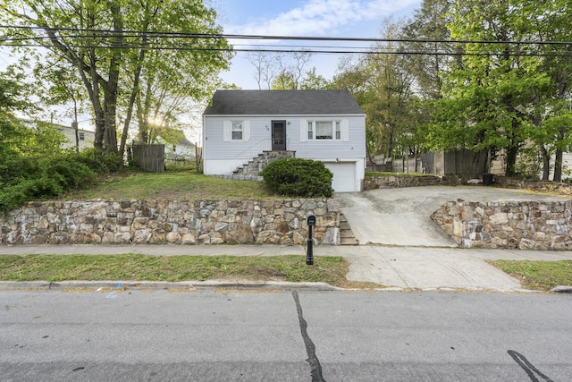 view of front of home featuring a garage, fence, and concrete driveway