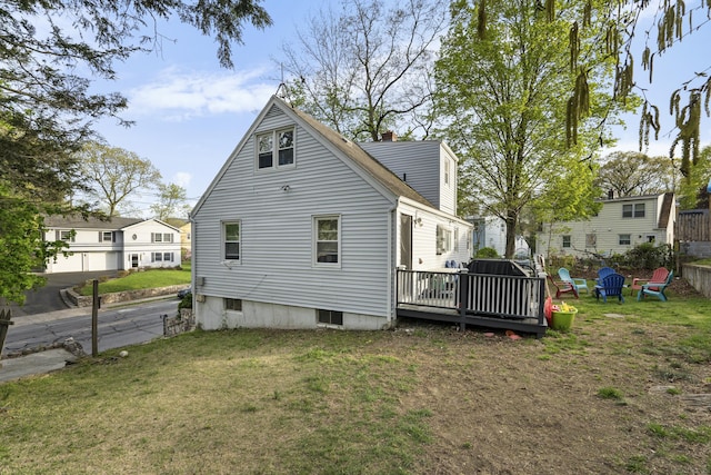 back of property featuring a yard and a deck