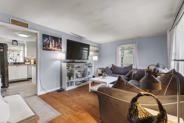 living area with baseboards and light wood finished floors