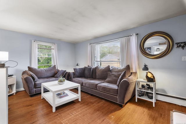 living area with baseboards, baseboard heating, and wood finished floors