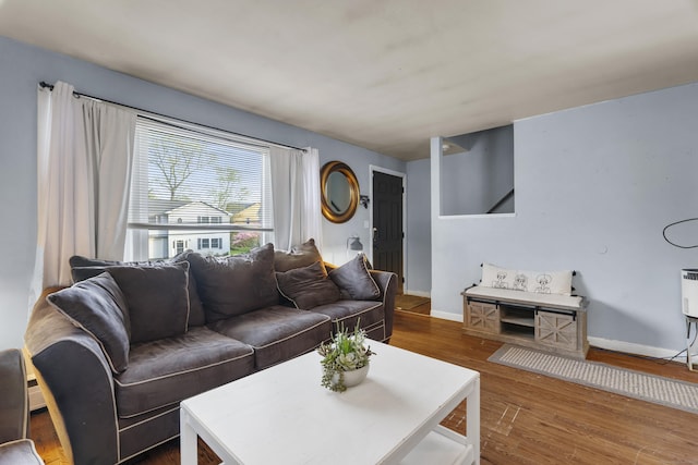 living room featuring baseboards and dark wood-type flooring
