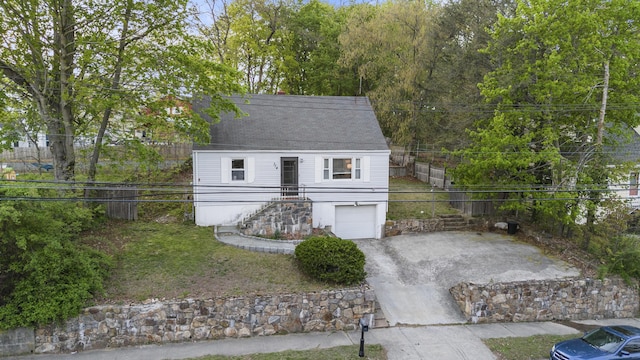 view of outdoor structure with driveway, fence, stairs, and a garage