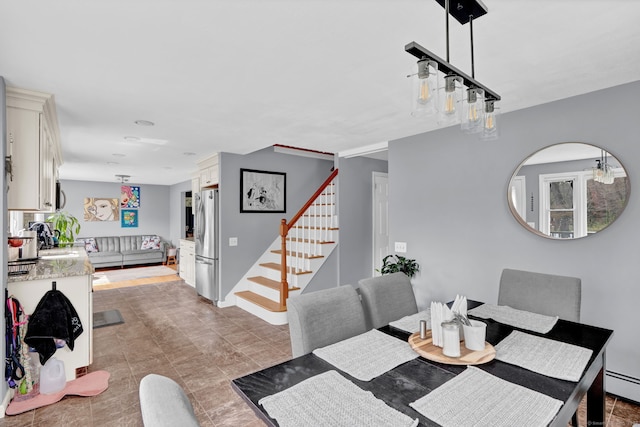dining room with stairway, light tile patterned floors, and a baseboard radiator