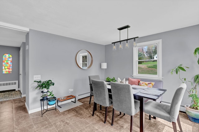 dining area with radiator, a baseboard heating unit, and baseboards
