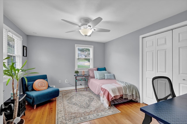 bedroom featuring light wood-style floors, a closet, and multiple windows